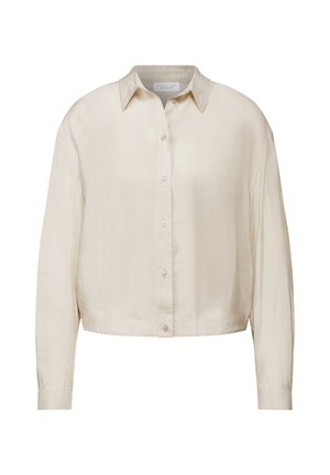 Kremowa, krótka koszula z guzikiem, z kołnierzykiem, długimi rękawami i zapięciem na guziki z przodu; wykonana z lekkiego materiału.