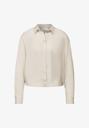 Kremowa, krótka koszula z guzikiem, z kołnierzykiem, długimi rękawami i zapięciem na guziki z przodu; wykonana z lekkiego materiału.