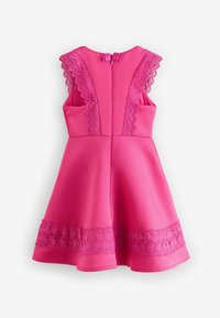 Rotes ärmelloses Kleid aus glattem Stoff, mit Spitzenakzenten an den Schultern und dem Saum, einem taillierten Oberteil und einem ausgestellten Rock.