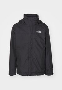 Veste imperméable noire North Face avec col montant, fermeture éclair frontale et boutons-pression, poignets réglables et logo sur la poitrine.