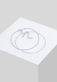 To sølvkæder i forskellige designs: den ene glat og tynd, den anden med tekstur og led. Begge har en lobster clasp-lukning.