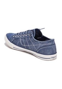 Sneaker in denim blu navy con cuciture bianche, suola in gomma e dettagli bianchi a contrasto. Caratterizzato da un design low-top e chiusura con lacci.