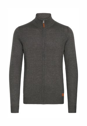 Grå zip-up tröja med hög krage, ribbad struktur och en liten läderdetalj längst ner till vänster. Långa ärmar och figursydd design.