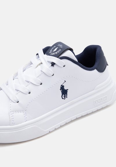 Hvit skinnsko med marineblå detaljer, snøring og Polo Ralph Lauren-logo med en polospiller på hesteryggen.