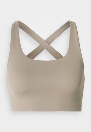 Beiger Sport-BH mit breiten, überkreuzten Trägern am Rücken, mit glatter, nahtloser Vorderseite und tiefem Rundhalsausschnitt.