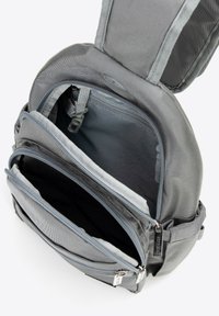 Szary plecak z tkaniny z wieloma przegrodami na suwak, pokazujący teksturowaną podszewkę wewnętrzną i kontrastujące czarne wnętrza. Wytrzymałe suwaki i detale pasków.