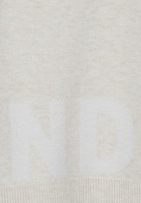 Cremfarbener Pullover mit strukturierter Oberfläche und großem weißen Schriftmuster. Verfügt über einen gerippten Saum und weichen Stoff.