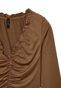 Blusa marrone a scollo a V con arricciature e bordi con volants, con maniche lunghe, presenta un'etichetta nera di taglia "CALLIOPE S" sul colletto.