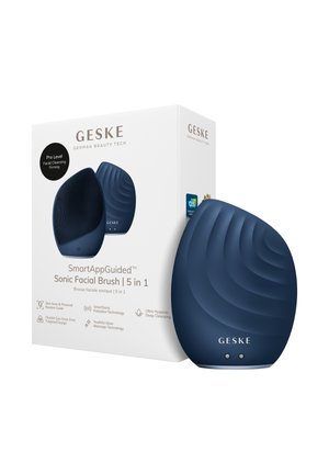 Mørkeblå dråbeformet sonisk ansigtsbørste med tekstureret overflade, vist ved siden af sin hvide æske mærket "GESKE SmartAppGuided 5 i 1."