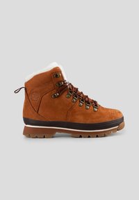 Bruine suède wandelschoen met witte pelsvoering, metalen oogjes en bruine veters. Heeft een robuuste rubberen zool met een gemusterde loop voor grip.
