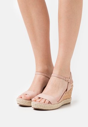 Wedge sandals with a pink suede upper, open toe, and ankle strap. Braided jute detailing on the wedge and a textured sole.