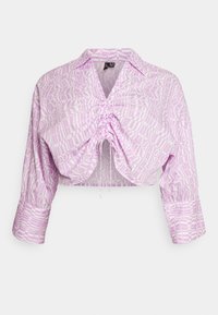 Blusa corta em roxo claro com um padrão geométrico. Apresenta um decote com colarinho e detalhe frontal franzido com cordões. Mangas longas.