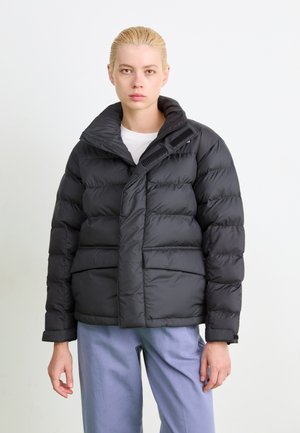 Svart puffjakke med overdimensjonert krage, glidelås og to frontlommer. Glatt tekstur med quilted detaljer og justerbare mansjetter.