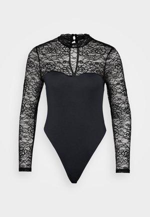 Bodysuit noir avec un design en dentelle à col haut et des manches longues. Tissu lisse sous la taille, coupé en style string. Détail en forme de trou de serrure au dos.