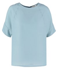 Blouse bleu clair à manches courtes avec col rond et coupe ample, en tissu lisse, avec une fermeture éclaire au dos.