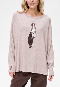 Jasnoróżowa bluzka z długim rękawem z haftowanym wzorem postaci w kolorze brązowym. Miękka w dotyku, o luźnym kroju; posiada małą metkę z logo na rękawie.
