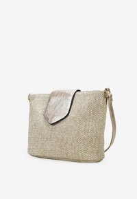 Bolso de mano tejido en color beige con una solapa metálica dorada, que presenta un diseño elegante, una textura sutil y una correa desmontable para mayor versatilidad.