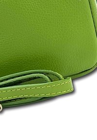 Groene leren tas met een gestructureerde afwerking. Beschikt over een bijpassende schouderband en contrasterende gele stiksels. Compacte en rechthoekige vorm.