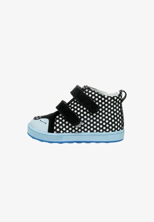 Sneaker pour enfant noir et blanc à pois avec deux bandes Velcro noires et une semelle bleu clair, vue de côté, isolée sur fond blanc.