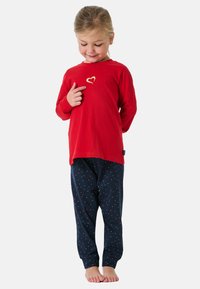 Rotes Langarmshirt mit goldener Herzgestaltung, kombiniert mit marineblauen Schlafanzughosen, die ein kleines, mehrfarbiges Punktmuster aufweisen.