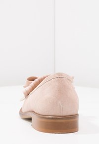 Růžová nubuková bota s řaseným detailem vzadu, kulatou špičkou a nízkým dřevěným podpatkem. Hladká textura a bezproblémový design.