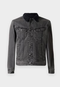 Jachetă din denim negru cu un guler pufos negru, având două buzunare pe piept, închidere frontală cu nasturi și mâneci lungi cu un design ajustat.