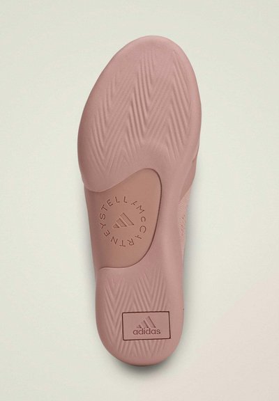 Suela de zapatilla rosa con un patrón texturizado de espina de pez, que presenta una impresión de logotipo circular y una caja de marca Adidas en el talón.