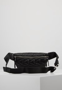 Mustat tikattu nahkavyölaukku, jossa on hopeinen vetoketju ja säädettävä musta hihna, esillä valkoisella pinnalla.