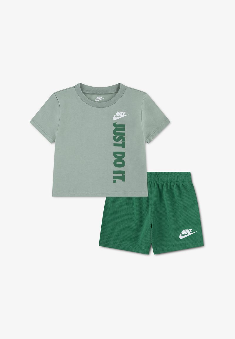 Πράσινο κοντομάνικο μπλουζάκι Nike με το κείμενο «JUST DO IT.» και ταιριαστό πράσινο σορτς με το λογότυπο της Nike στο αριστερό πόδι.