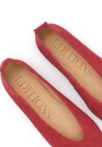 Ζευγάρι μπαλαρίνες από κόκκινο σουέντ με ταμπά εσωτερικές σόλες, με την επωνυμία "Kazar Editions" σε λευκό φόντο.
