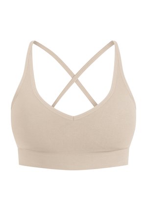 Brassière de sport beige avec un col en V, comportant des bretelles croisées dans le dos et une bande élastique texturée en bas.