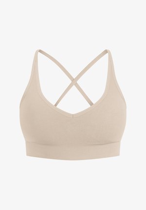 Brassière de sport beige avec un col en V, comportant des bretelles croisées dans le dos et une bande élastique texturée en bas.