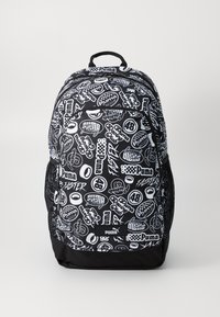 Black and white backpack featuring a mix of logos and text patterns. Made of durable fabric with mesh side pockets and a top handle.