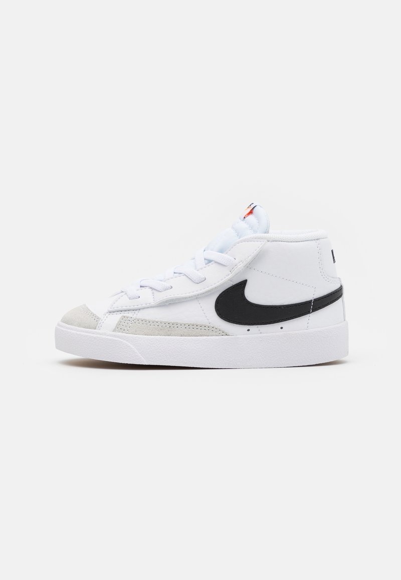 Tenisky Nike Blazer Mid mají bílý kožený svršek, šedou semišovou špičku, černý swoosh a strukturovanou bílou gumovou podrážku.