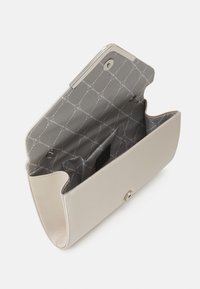 Beige nahkakotelo, jossa on sileä pinta, metallinen kiinnike ja harmaasta kuviollisesta sisustasta koostuva yksittäinen lokero ja sivutasku.