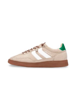 Zapatilla deportiva beige hecha de ante con suela de goma marrón, que presenta tres rayas blancas en el lateral y un acento verde en el talón.