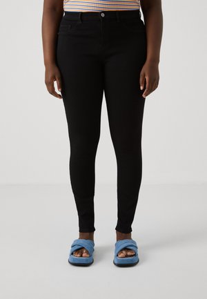 Svarta skinny jeans i denim med en slät textur. Bärs med blå slidesandaler med en snodd remdesign.
