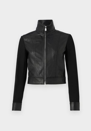 Μαύρο μπουφάν με δερμάτινο σώμα και πλεκτά μανίκια, κοντό σχέδιο, ψηλό λαιμό, μπροστινό φερμουάρ και δερμάτινους καρπούς. Λείο υλικό.