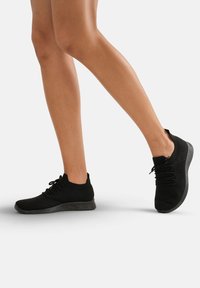 Zwarte gebreide sneakers met een laag uitgesneden ontwerp, ronde neus, textuur bovenwerk en een comfortabele zwarte zool met veters voor een veilige pasvorm.