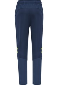 Marineblauwe sportbroek gemaakt van ademende stof, met een taps toelopend ontwerp en groene accenten aan de zijkanten. Elastische tailleband bovenaan.