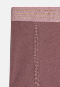 Rosa elastisk midjeband med tre horisontella gyllene ränder; mjukt, texturerat tyg; inkluderar en söm i mitten och ribbat mönster.