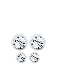 Pendientes de plata con tachuelas que presentan cristales transparentes, redondos y de dos tamaños, con una base metálica suave y un acabado pulido.