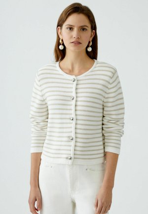 Striped cardigan in cream and beige, knit material, round neckline, long sleeves, five silver buttons down the front, ribbed cuff details.