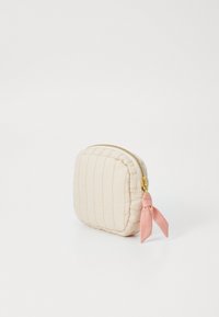 Quiltet beige veske med gullglidlås og rosa bånddetalj, med firkantet form og subtilt stingmønster. Kompakt og myk tekstur.