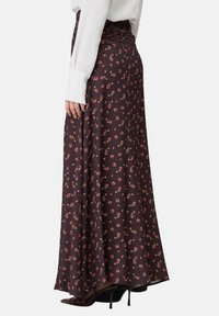 Gonna maxi in tessuto marrone scuro con piccoli motivi floreali rosa, vita elastica, design fluido e texture liscia.