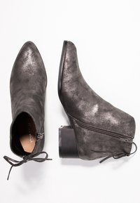 Černé metalické kotníkové boty s špičatou špičkou a texturovaným povrchem. Obsahují boční zip, šněrování kolem kotníku a robustní blokový podpatek.