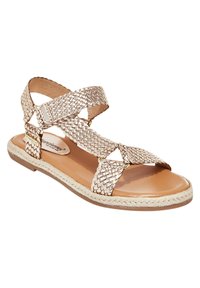 Vävda metalliska guld sandaler med korsade remmar, tan läder innersula och repdetaljer längs sulan. Öppen tå-design.