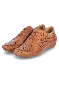 Zapatos de cuero marrón claro con diseño perforado, forma curveada y detalles de costura contrastantes. Ligeros, diseñados para la comodidad, con un tacón bajo.