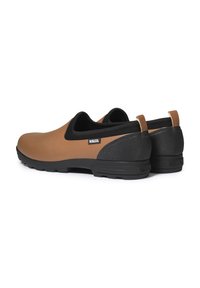 Chaussures en caoutchouc marron avec des accents noirs, design slip-on, talon texturé et semelle moulée. Présente le logo Aigle sur le côté.