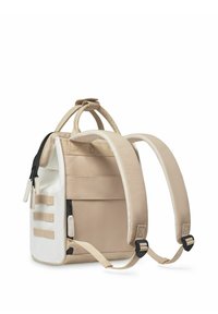 Beige stoffen rugzak met een gestructureerd ontwerp, voorzien van een witte zijpaneel, verstelbare gewatteerde schouderbanden en ritsen aan de bovenkant.